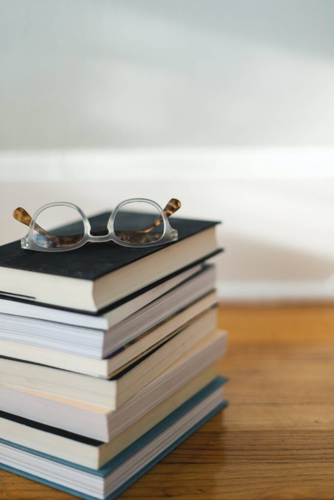 stack of books with eyeglasses on top